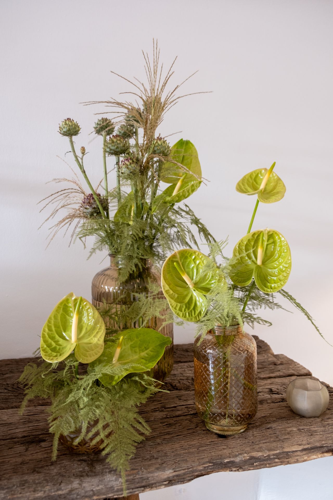 bouquets de fleurs vertesur table en bois et mur blanc