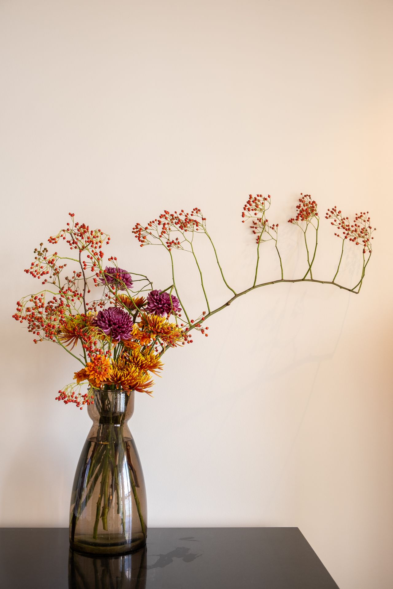 Un bouquet de fleur jaune et rose sur table noir et mur blanc