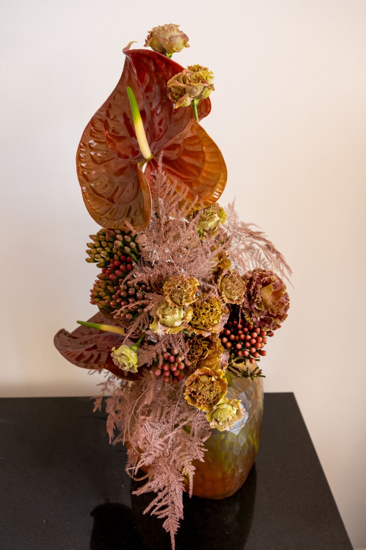 Un bouquet de fleur rouge avec un anthurium et un mur blanc